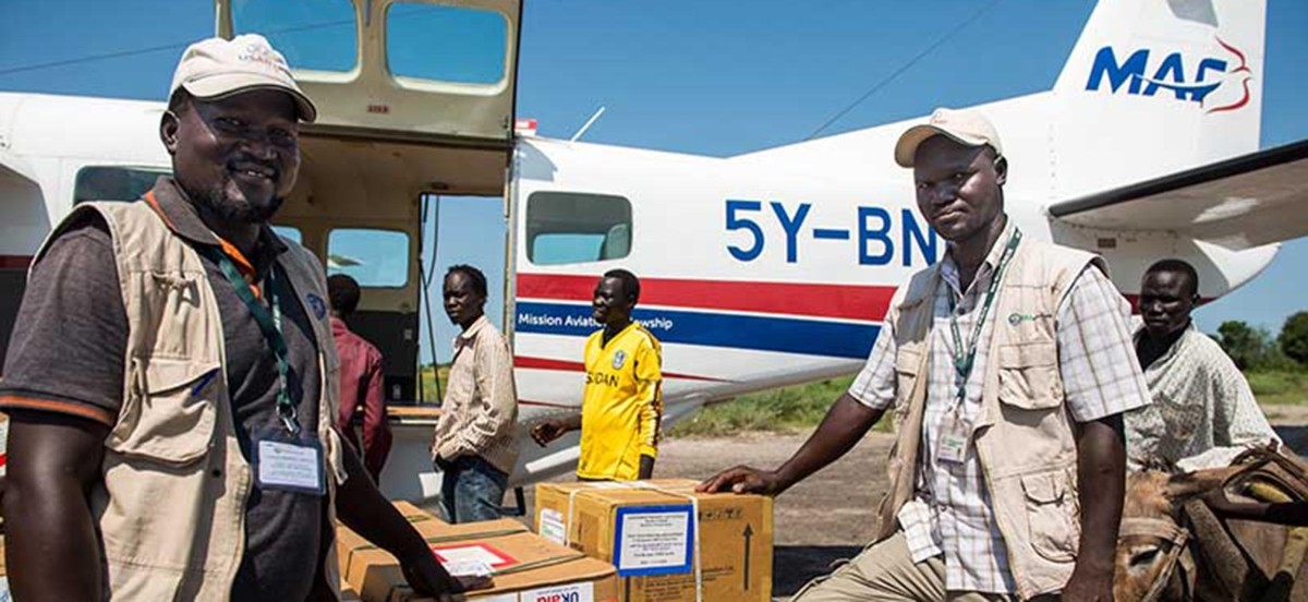 Corus World Health Medical Supervisor Dr. Oleny Amum and Field Operations Coordinator Serunkuma Luigi Adwo make sure the cargo — medicine and medical supplies — flown in on the MAF Cessna Caravan get to people who need it most. (MAF/LuAnne Cadd) 